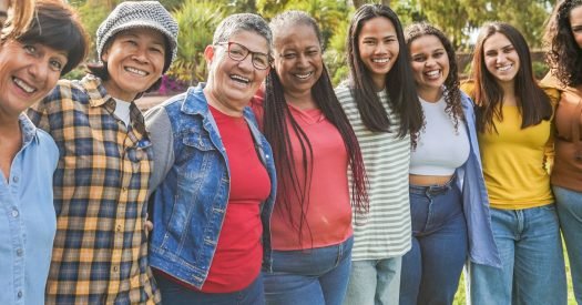 Multi generational women smiling in front of camera - Female multiracial group having fun togheter outdoor - Main focus on woman face with glasses